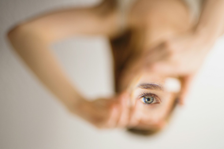 Ein blaues Auge schaut direkt aus der Mitte des Bildes, der Rest eines Gesichts und Körpers ist verschwommen.
